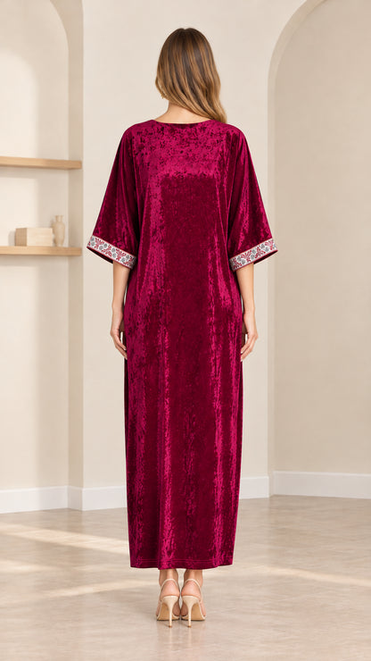 Back view of model wearing loose fit burgundy velvet kaftan dress