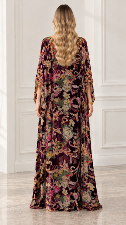 Back view of woman wearing full-length burgundy floral velvet caftan gown