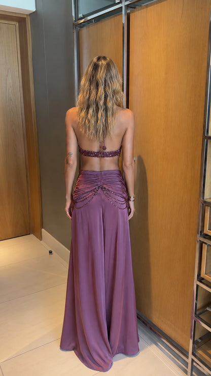 Back view of model showing open back beaded halter top and flowing mauve skirt