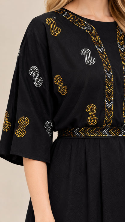 Close-up detail of metallic rhinestone embellishment on the black fabric
