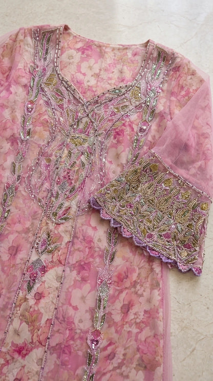 Close-up detail of ornate beadwork and scalloped embroidered cuffs on pink chiffon kaftan