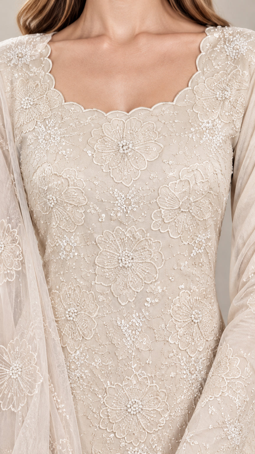 Close-up detail of champagne floral embroidery, beadwork, and scalloped neckline