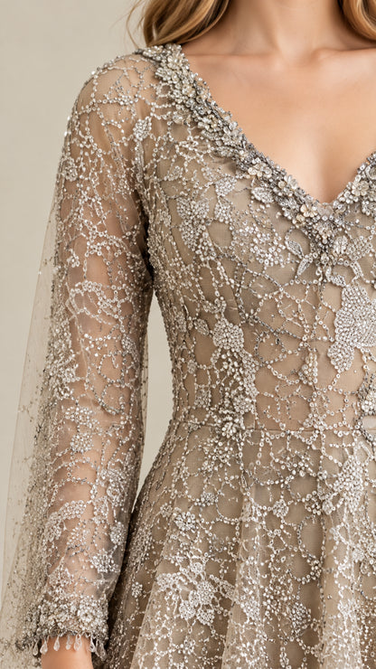 Close-up of intricate silver beadwork, V-neckline, and sheer embroidered sleeve