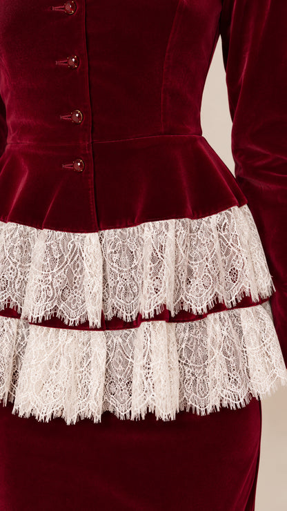 Close-up detail of tiered floral lace trim and button accents on velvet peplum bodice