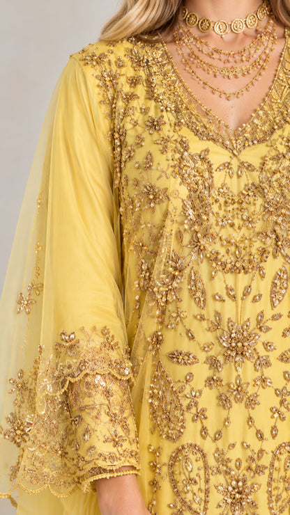 Close-up detail of ornate gold sequin and thread embroidery on yellow kaftan dress