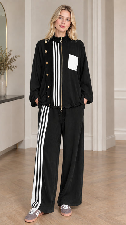 Full-body view of woman wearing black and white colorblock tracksuit set
