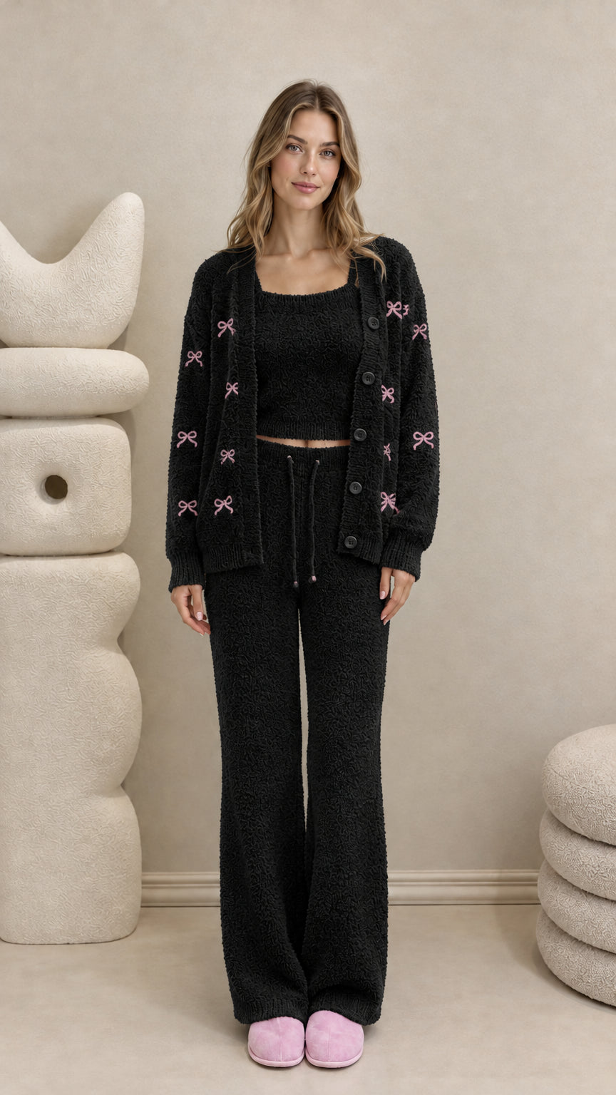 Model wearing black 3-piece fuzzy knit lounge set with pink embroidered bows