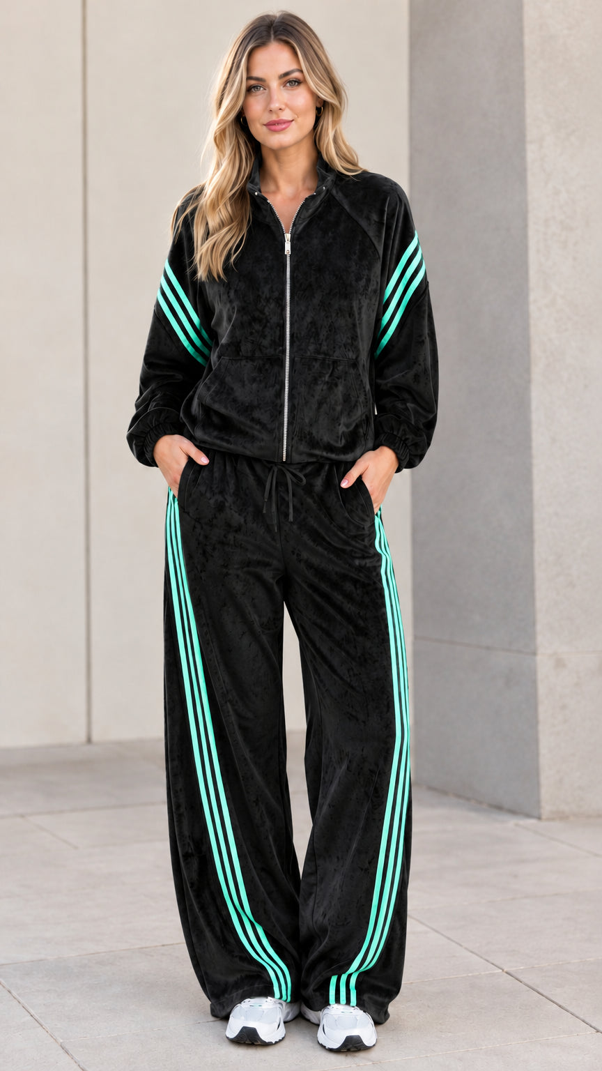 Model wearing black velour tracksuit set with mint contrast stripes