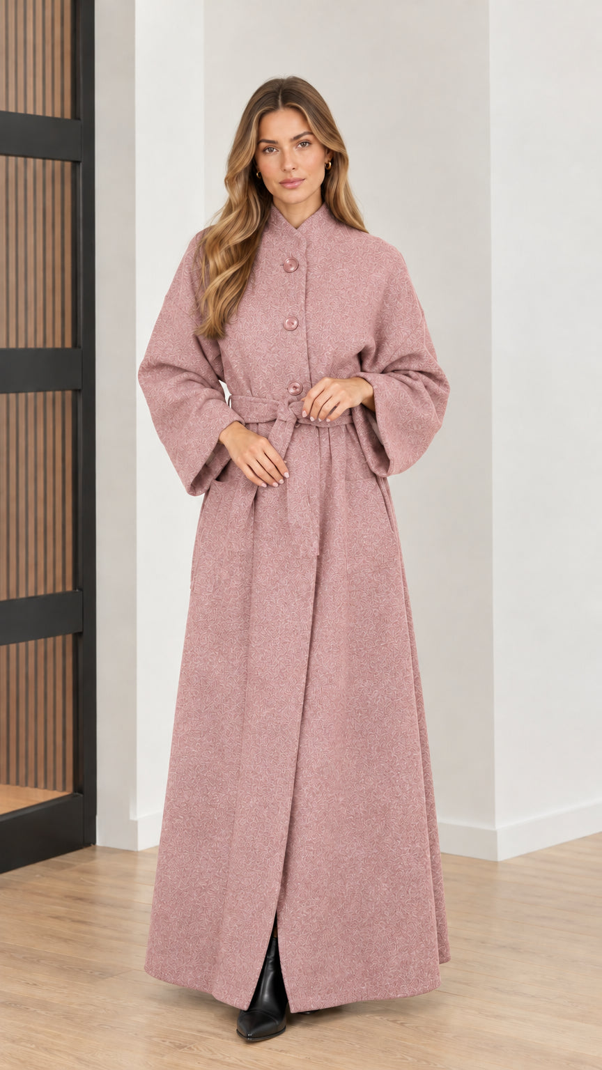 Front view of woman wearing dusty pink belted maxi overcoat
