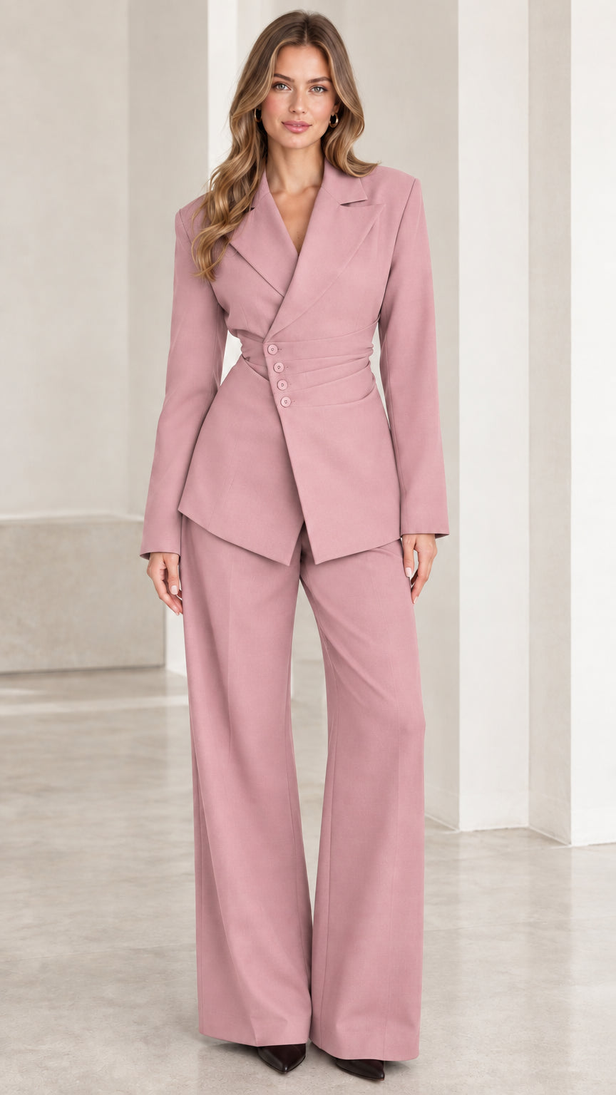 Front view of woman wearing dusty pink asymmetric blazer and trouser set