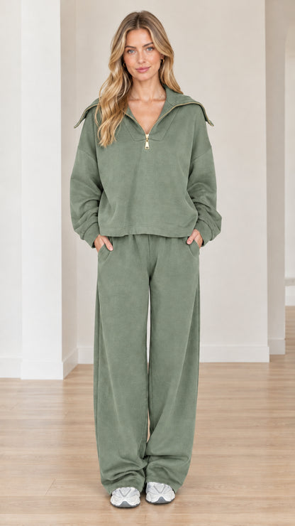 Model wearing sage green two-piece half-zip sweatsuit with wide-leg pants