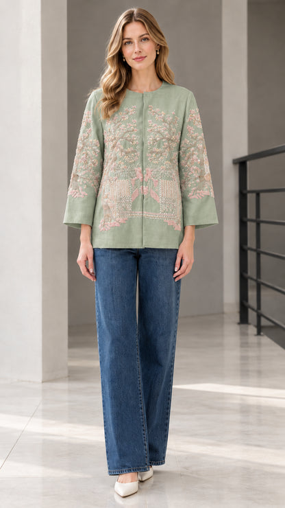 Sage green floral embroidered collarless jacket modeled with blue jeans