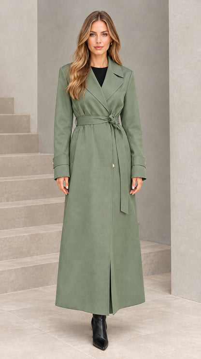Front view of woman wearing sage green maxi belted trench coat