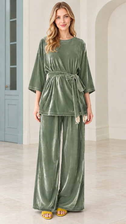Model wearing sage green velvet belted top and wide leg pants matching set