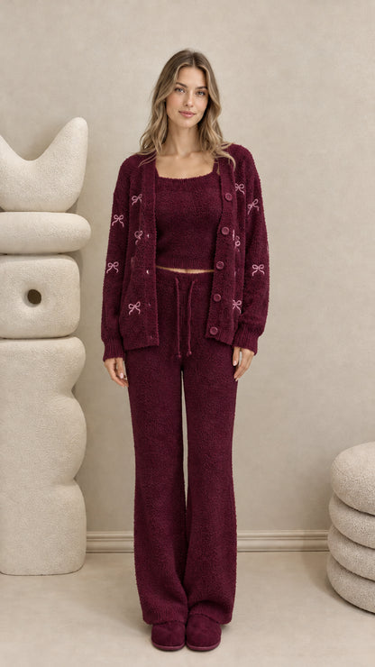 Model wearing burgundy 3-piece plush knit lounge set with pink embroidered bows