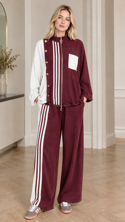 Full-body view of woman wearing burgundy wine red colorblock tracksuit set