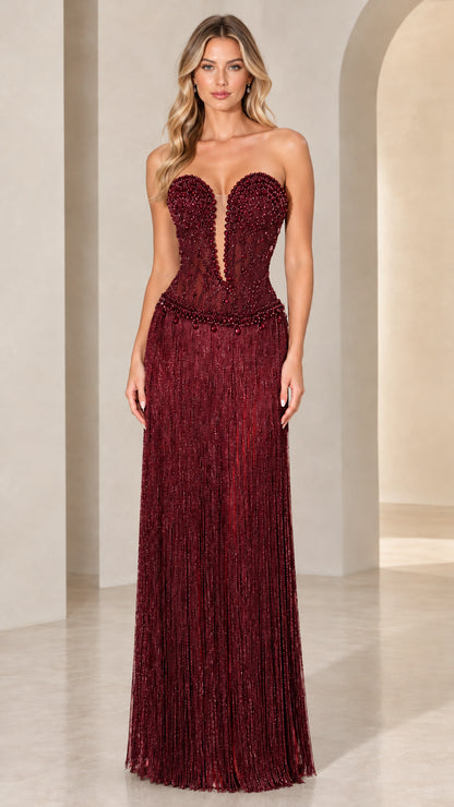 Front view of model wearing Burgundy strapless beaded corset fringe evening gown