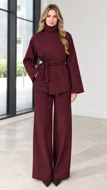 Full view of women's burgundy asymmetrical belted jacket and wide-leg pants set