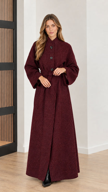 Front view of woman wearing deep burgundy red belted maxi overcoat