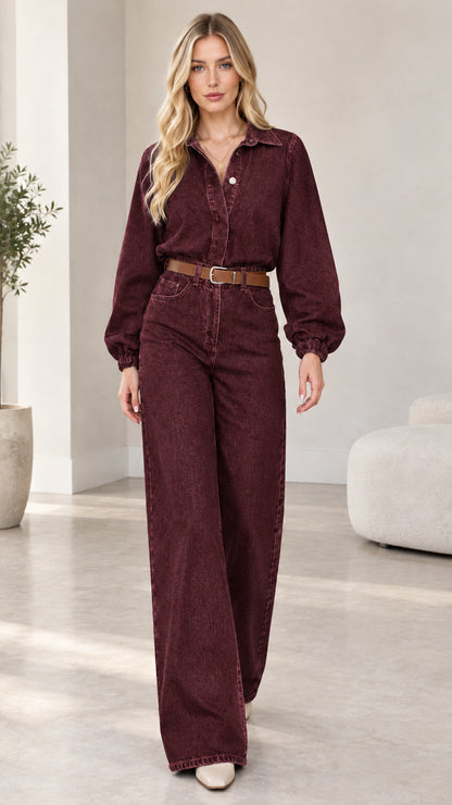 Model wearing burgundy plum wide-leg denim jumpsuit with brown belt