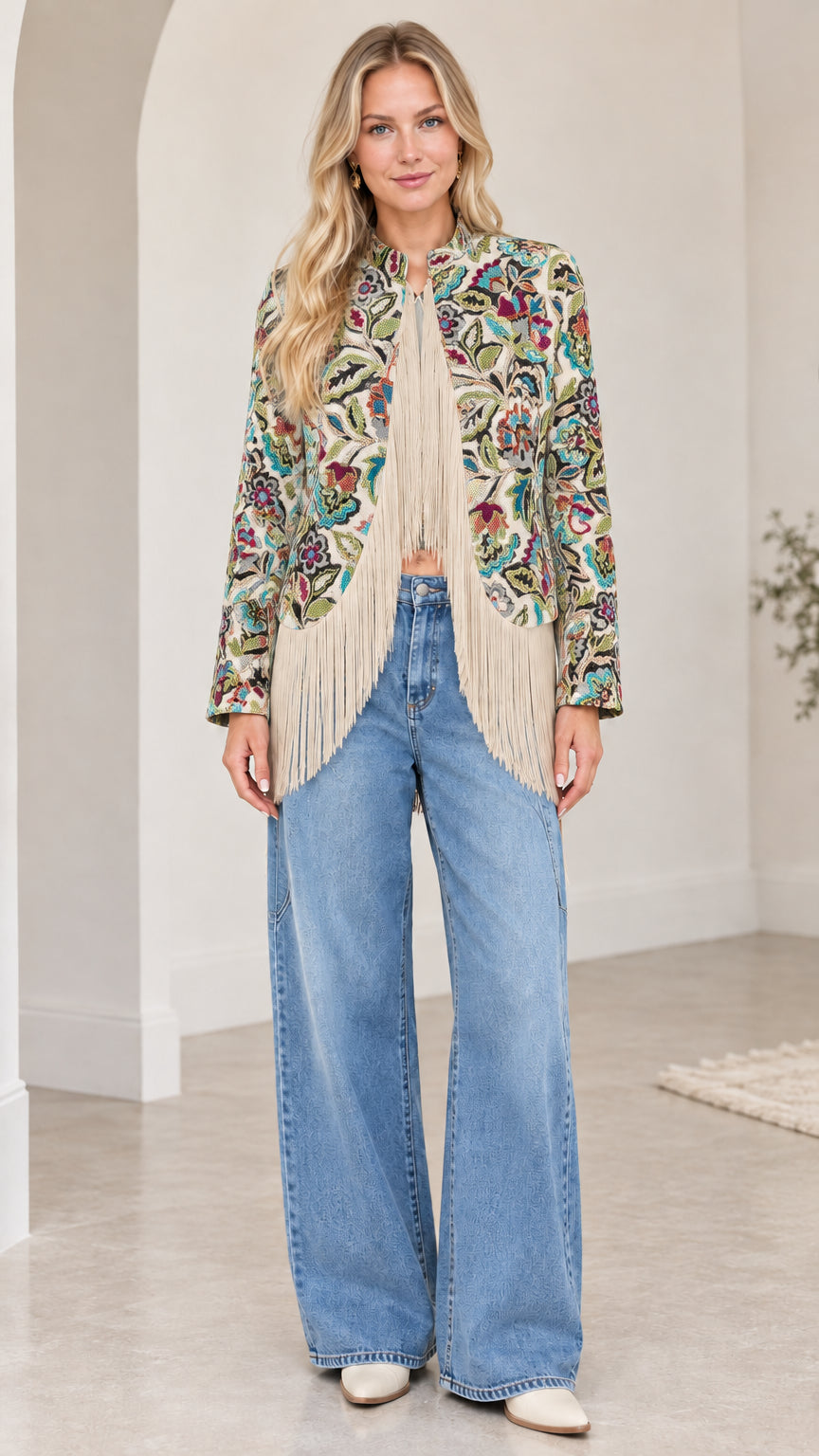 Model wearing cream and multicolored floral tapestry jacket with ivory fringe