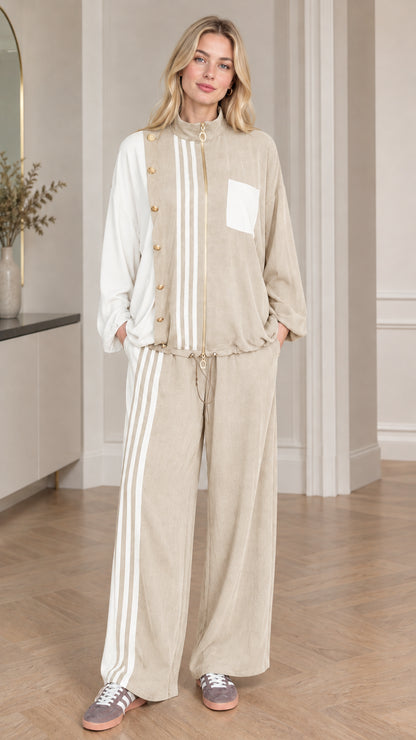 Full-body view of woman wearing beige khaki colorblock tracksuit set