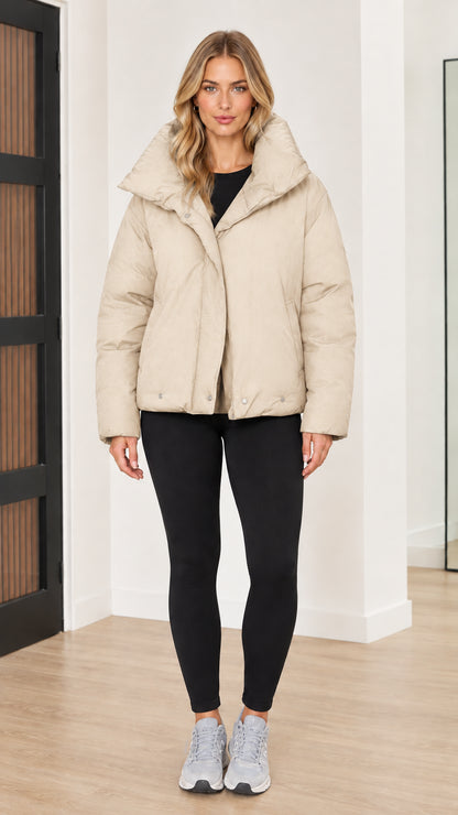 Front view of woman wearing cream beige funnel collar puffer jacket
