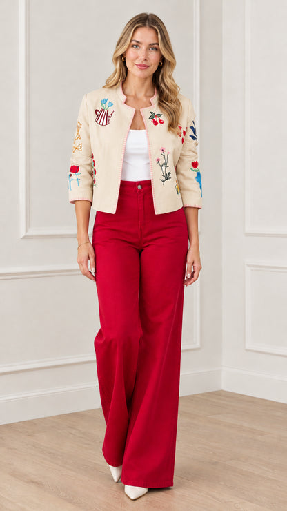 Beige whimsical embroidered cropped jacket styled with red trousers