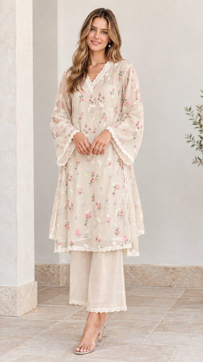 Full-length view of woman wearing beige floral embroidered tunic and pant set