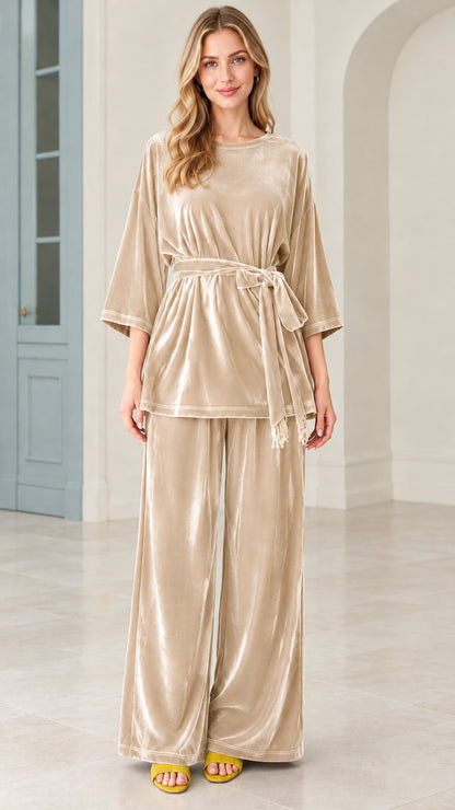 Model wearing champagne beige velvet belted top and wide leg pants matching set